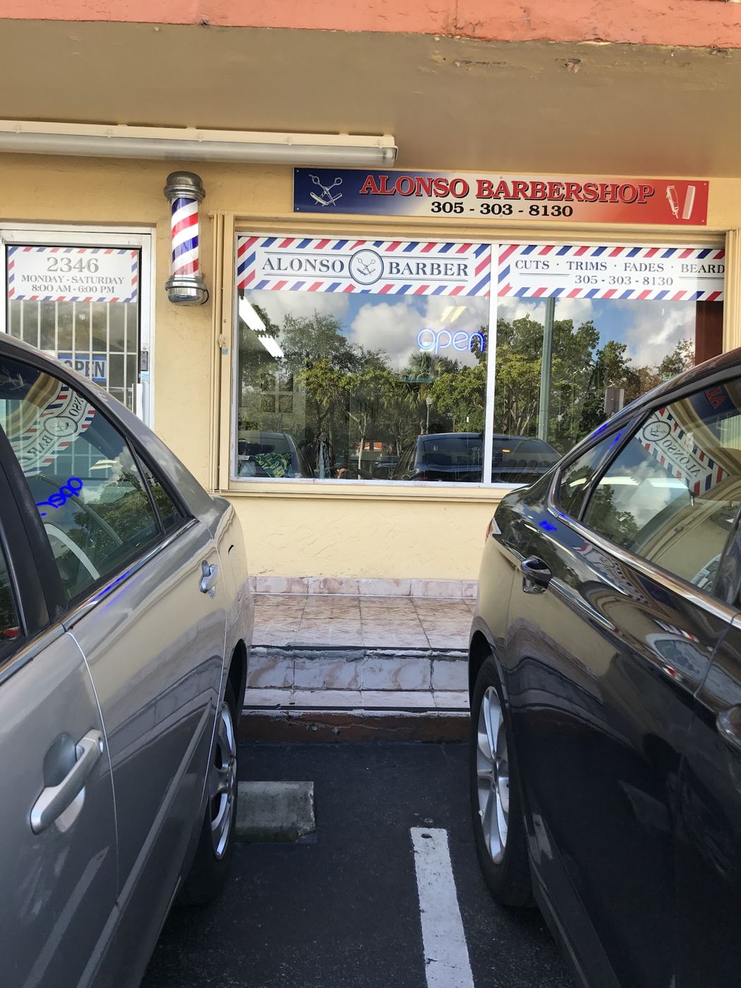 Fachada de Alonso Barbershop con poste de barbero